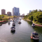 Couple boating in Songdo Central Park, Incheon with modern buildings in the background